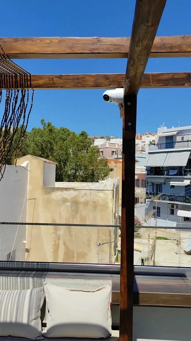 Surveillance camera on a rooftop pergola overlooking the town