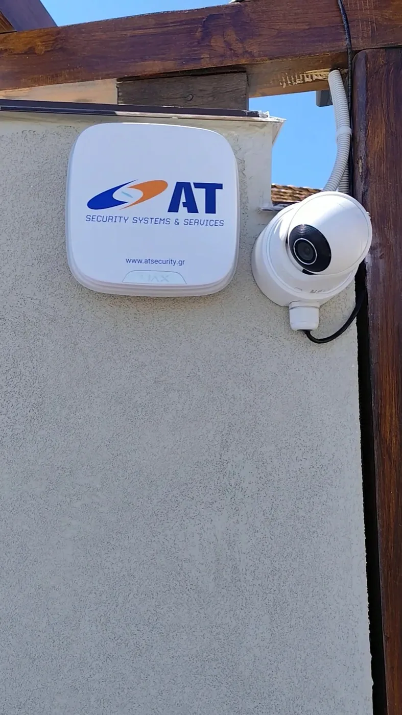 Ajax outdoor siren with AT Security branding next to a camera